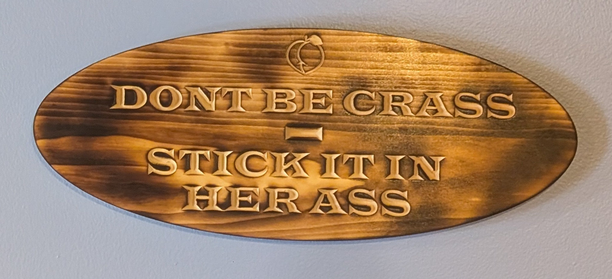 Wooden plaque with text on a plain wall